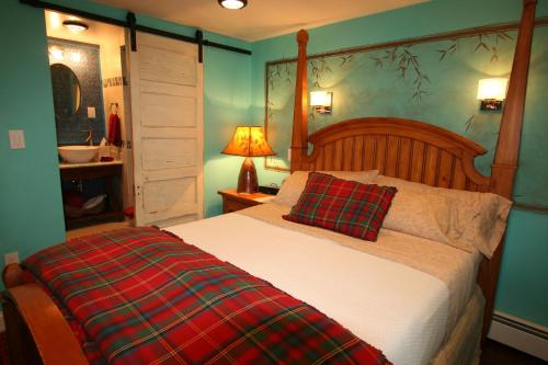 a bedroom with a bed with a plaid pillow on it at Alpenhof Bed & Breakfast in Media