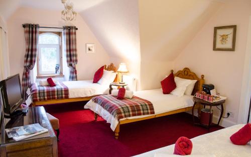 a room with two beds and a tv at RossMor Bed & Breakfast in Grantown on Spey