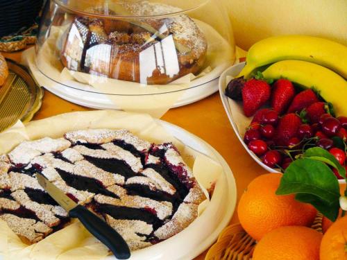 a table topped with plates of food and fruit at B&B President Palace in Riposto