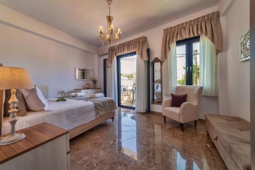 ein Schlafzimmer mit einem Bett, einem Stuhl und einem Fenster in der Unterkunft Kallisti in Panormos