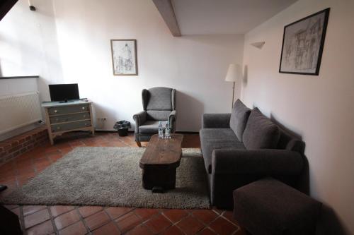 a living room with a couch and a chair at Zamek Reszel in Reszel