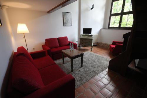 a living room with red couches and a table at Zamek Reszel in Reszel