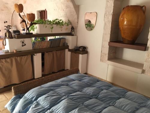 una camera con letto blu in una stanza con scaffali di B&B Via dei Trulli a Cisternino