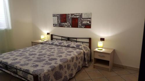 sypialnia z łóżkiem i 2 szafkami nocnymi w obiekcie Casa Vacanza Sardegna w mieście Valledoria