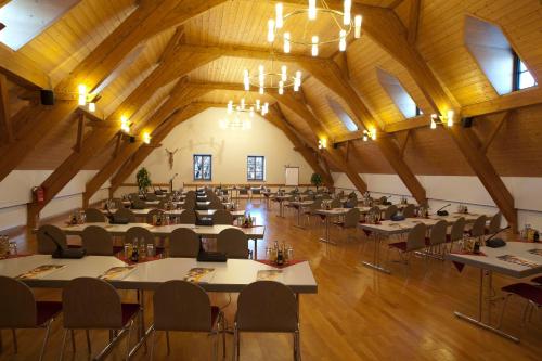 ein großes Zimmer mit Tischen und Stühlen in der Unterkunft Haus Chiemgau - Kolping-Familienhotel in Teisendorf