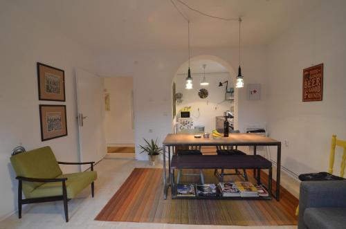 ein Wohnzimmer mit einem Tisch und einem Stuhl in der Unterkunft Embassy of Industry + free parking in Sarajevo