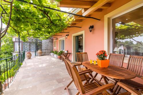 an outdoor patio with wooden tables and chairs at Milena's Country House in Pelekas
