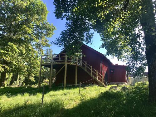 a red barn sitting on top of a grass field at Björnåsen Bear Hill in Katrineholm