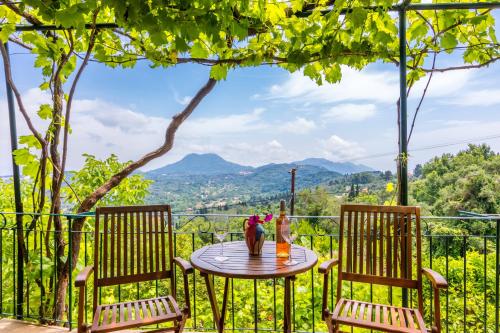a table and chairs on a balcony with a view at Milena's Country House in Pelekas