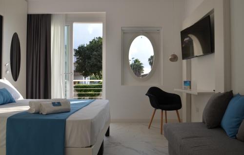 a bedroom with a bed and a couch and a mirror at Centurio luxury rooms in Tropea