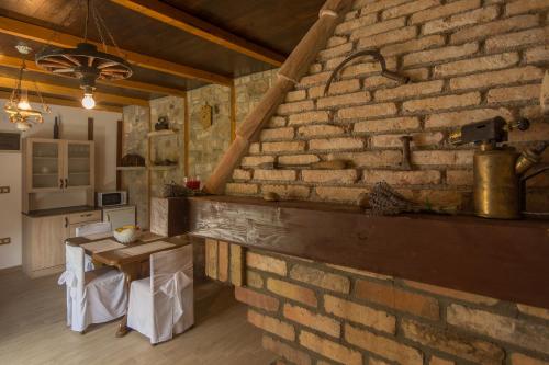 eine Backsteinwand in einem Zimmer mit einem Tisch und einer Küche in der Unterkunft Casa Mala in Zadar