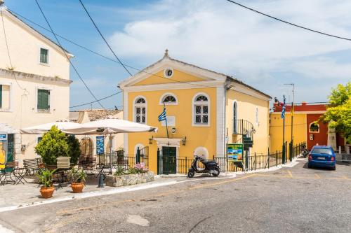 a yellow building with a scooter parked in front of it at Milena's Country House in Pelekas