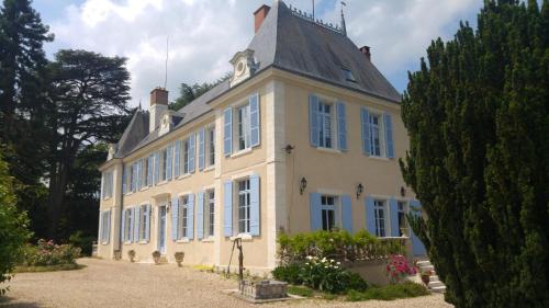 PouilléにあるManoir de la Voute maison d'hôtesの時計塔のある白い大きな建物