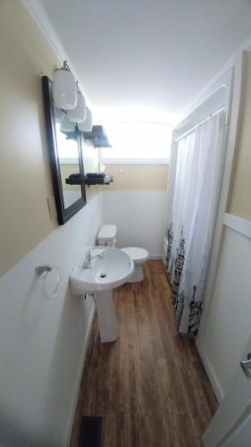 a bathroom with a sink and a toilet and a mirror at Steps to the Waterfront in Shelburne