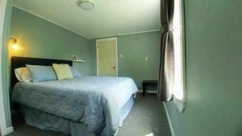 a bedroom with a bed in a green room at Steps to the Waterfront in Shelburne
