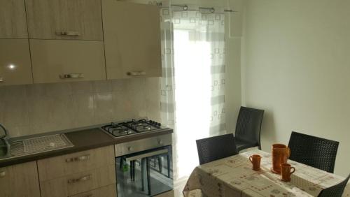 uma cozinha com uma mesa, um fogão e uma bancada em La casa di Luvy em Ostuni