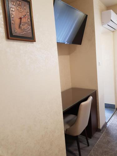 a desk with a chair and a clock on a wall at Stan 110 in Orašje