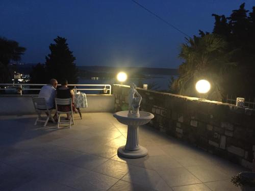 two people sitting on a patio at night at Apartments Heidi in Portorož