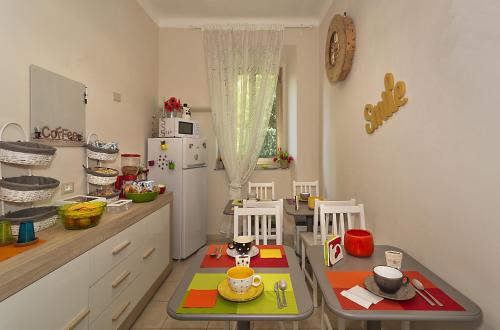 eine Küche mit einem Tisch, 2 Stühlen und einem Kühlschrank in der Unterkunft A due passi dalla torre in Pisa