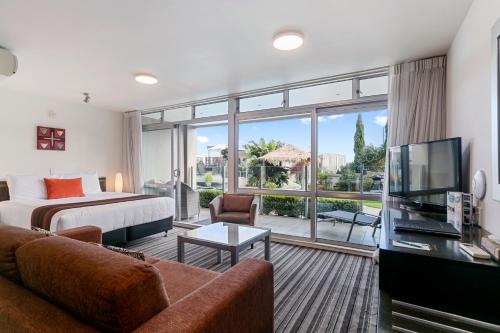 a hotel room with a bed and a large window at The Reef Resort in Taupo