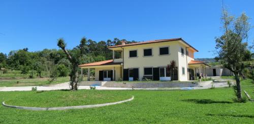 a house with a green lawn in front of it at Casa das Oliveiras in Beiral do Lima