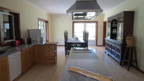 a kitchen with a table and a dining room at Casa das Oliveiras in Beiral do Lima