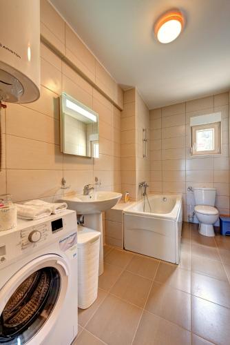 a bathroom with a washer and a sink and a washing machine at Apartments Villa Adriatic in Tivat