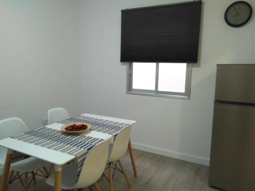 uma cozinha com uma mesa com cadeiras e um frigorífico em Habitaciones IFAE em Alcalá