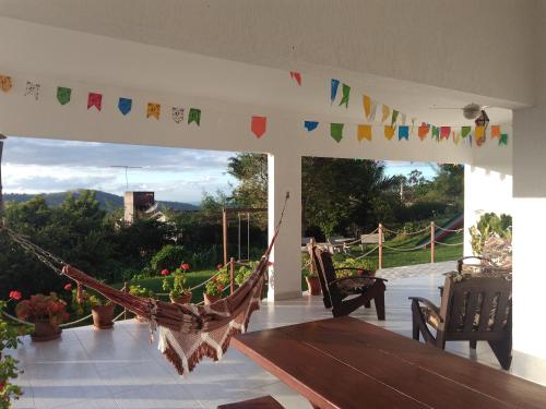 a porch with a hammock on a patio with a view at Casa Schneider in Gravatá