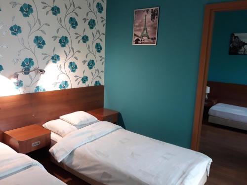 1 dormitorio con 2 camas y una pared con flores en Bed & Breakfast Green Roof, en Rybarzowice