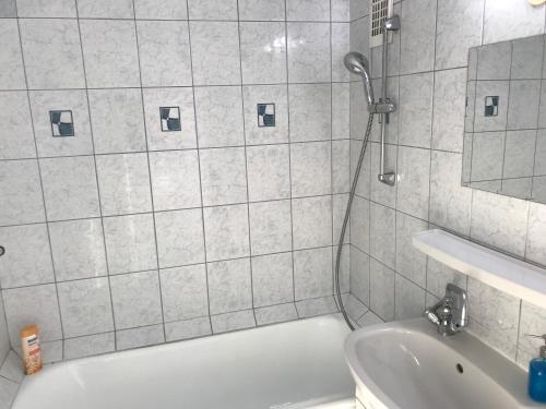 a bathroom with a shower and a tub and a sink at PanoramaPanel in Budapest
