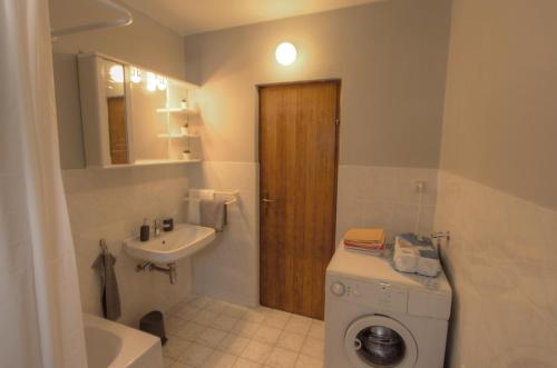 a bathroom with a washing machine and a sink at Apartman Toni in Lukoran