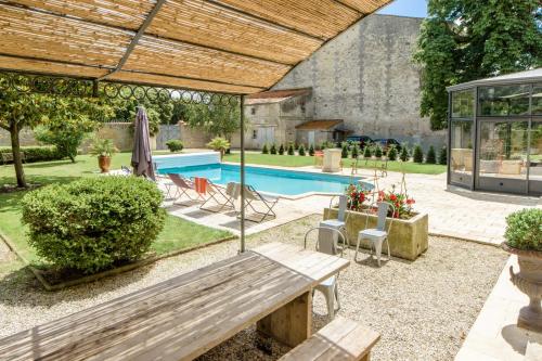 a patio with a bench and a swimming pool at L'esprit du 8 in Rochefort