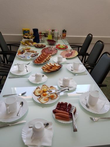 a long table with plates of food on it at Pansion Bojic in Međugorje
