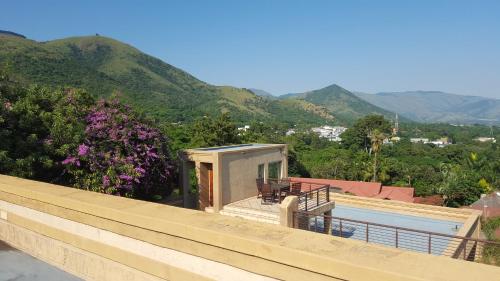 a house with a swimming pool and mountains in the background at Bubez Guesthouse in Barberton