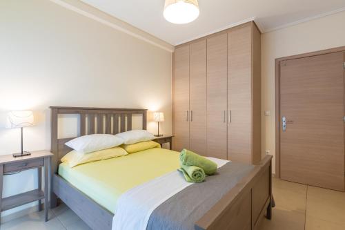 アテネにあるPatissia Apartmentのベッドルーム1室(大型ベッド1台、木製ヘッドボード付)