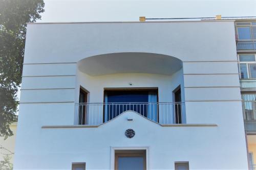 a white building with a balcony on top of it at Bora B&B in Troia