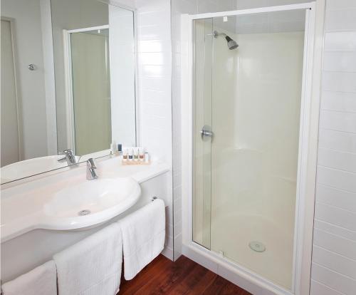 a white bathroom with a sink and a shower at Boulevard Waters in Taupo