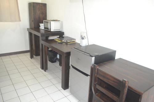 eine Küche mit einem Tisch, einem Kühlschrank und einer Mikrowelle in der Unterkunft Hotel Don Fito in Golfito