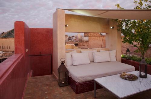 uma cama no topo de uma varanda com uma mesa em P´tit Habibi em Marrakech