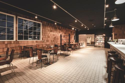 a restaurant with tables and chairs in a room at Noboribetsu Guest House AKA & AO in Noboribetsu