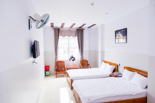 a hotel room with two beds and a window at Hoang Thinh Hotel in Kon Tum