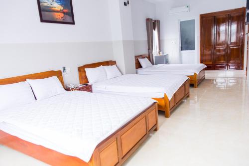 a group of three beds in a room at Hoang Thinh Hotel in Kon Tum