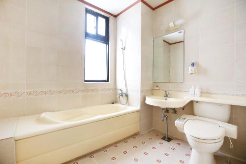 a bathroom with a tub and a toilet and a sink at Venus Motel in Boryeong