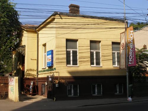 una casa amarilla al lado de una calle en Kretan Hostel, en Bucarest