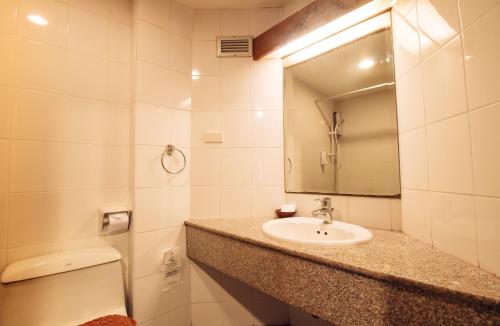 een badkamer met een wastafel en een spiegel bij Ayothaya Hotel in Phra Nakhon Si Ayutthaya