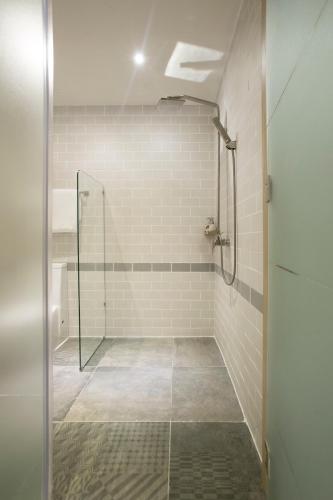 a shower stall with a glass door in a bathroom at Fusion Suites Saigon in Ho Chi Minh City