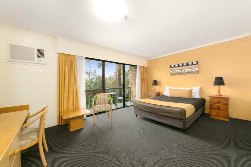 Habitación de hotel con cama y escritorio en Mt Ommaney Hotel Apartments en Brisbane