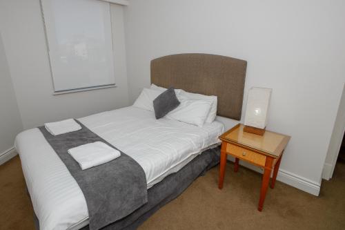 a small bedroom with a bed and a table at Bond 1603 Self Catering in Sydney