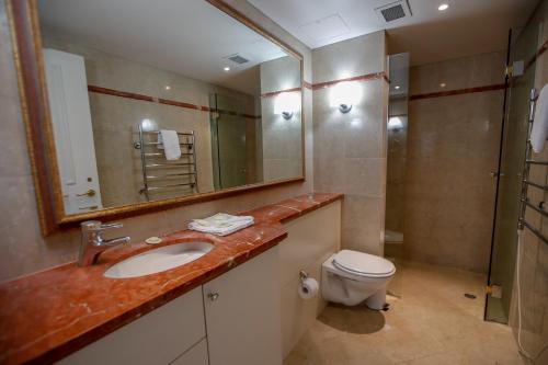 a bathroom with a sink and a toilet and a mirror at Bond 1603 Self Catering in Sydney